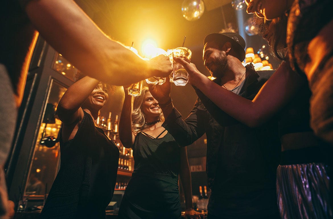 Nightlife public safety includes people celebrating with alcoholic drinks in bar.